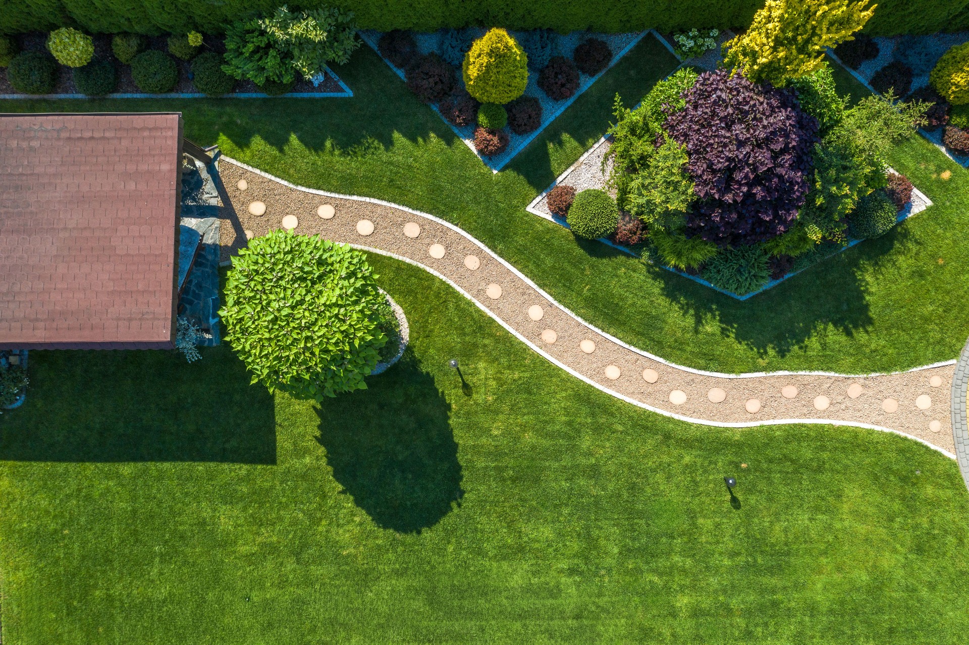 Beautiful Garden Design With Lush Greenery and Decorative Pathway in Sunlight
